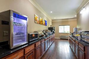 a kitchen with a counter with a large refrigerator at Comfort Inn Huntsville near University in Huntsville