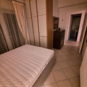 ein Schlafzimmer mit einem weißen Bett in einem Zimmer in der Unterkunft piu verde1 in Nea Makri