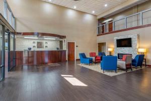 a lobby with a waiting area with blue and red chairs at Comfort Suites near Robins Air Force Base in Warner Robins