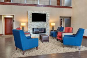 a lobby with blue chairs and a fireplace at Comfort Suites near Robins Air Force Base in Warner Robins