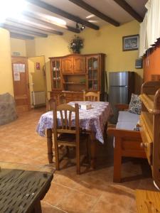 ein Esszimmer mit einem Tisch und einem Kühlschrank in der Unterkunft Casa Rural La Curva in Barajas de Gredos