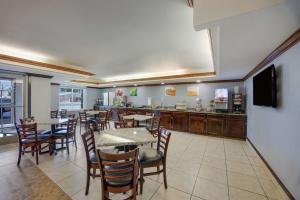 restauracja ze stołami i krzesłami oraz bar w obiekcie Quality Inn & Suites w mieście Clayton