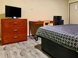 1 dormitorio con 1 cama y vestidor con TV en Rodeway Inn Sacramento-University Area, en Sacramento