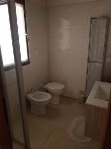 a white bathroom with a toilet and a sink at Residence Concaverde in Pomarolo