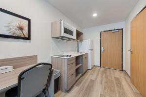 eine kleine Küche mit einem Schreibtisch und einer Mikrowelle in der Unterkunft WoodSpring Suites Meridian in Meridian