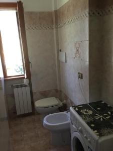 a small bathroom with a toilet and a sink at Appartamento a Marina di San Nicola Roma in Palo