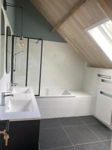 uma casa de banho com um lavatório branco e um chuveiro em LA GRANGE em Anzin-Saint-Aubin