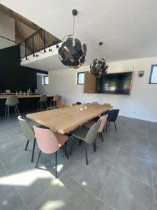 uma sala de jantar com uma mesa de madeira e cadeiras em LA GRANGE em Anzin-Saint-Aubin