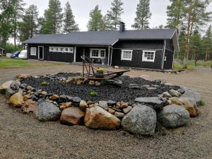 ein Haus mit einem Steingarten davor in der Unterkunft Maglelin Experience Lodge in Kittilä