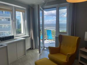 uma sala de estar com uma cadeira e vista para o oceano em Wolin-Travel Campingowa z widokiem na morze em Międzyzdroje