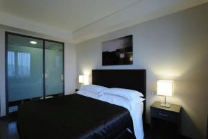 a bedroom with a bed with two lamps and a window at Park Hotel Sporting in Teramo