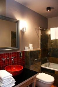 a bathroom with a red sink and a toilet at Hotel Browar Kościerzyna in Kościerzyna