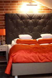 a bedroom with two beds and a black headboard at Hotel Browar Kościerzyna in Kościerzyna