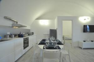 uma cozinha branca com uma mesa e cadeiras brancas em A marina on Bussana Sanremo seaside em Bussana Nuova