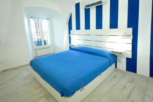 um quarto com uma cama com riscas azuis e brancas em A marina on Bussana Sanremo seaside em Bussana Nuova