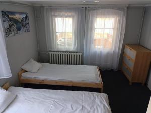 two beds in a small room with two windows at Ośrodek Wypoczynkowy Nad Wodospadem in Przesieka