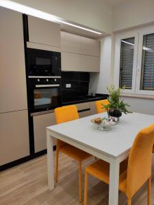 - une cuisine avec une table blanche et des chaises orange dans l'établissement Casa Magrè, à Agrigente