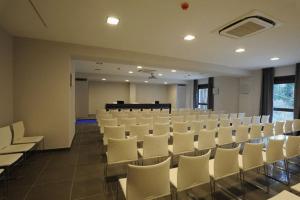 a large room with white chairs and tables and a unintention at Park Hotel Sporting in Teramo