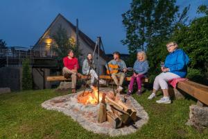 a group of people sitting around a fire pit at Zum Kuckuck in Schonach