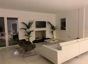 een witte woonkamer met een witte bank en stoelen bij Villa luxury con piscina in Mesagne