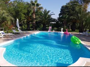 een groot blauw zwembad met een groene opblaasbare bij Villa luxury con piscina in Mesagne
