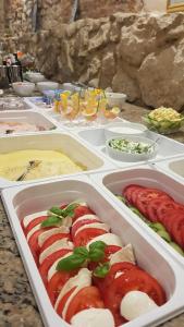 a buffet of hot dogs and other foods in trays at Hotel Eden in Kraków