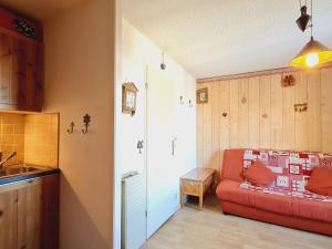 a living room with a red couch and a kitchen at Studio Les Deux Alpes, 1 pièce, 4 personnes - FR-1-348-261 in Les Deux Alpes