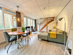 a living room with a table and a couch at Aparthotel Bos en Duin Texel in Den Hoorn