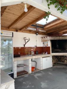 uma cozinha com tectos em madeira e uma bancada em Apartman Jole em Razanj