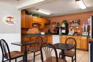 eine Küche mit 2 Tischen und einem Kühlschrank in der Unterkunft Super 8 by Wyndham Concordia in Concordia