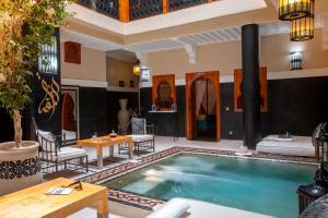 a large swimming pool in a room with a house at Riad Rodaina in Marrakesh