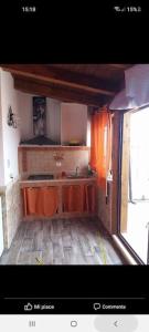 małą kuchnię z drewnianymi szafkami i zlewem w obiekcie Stella Mare w mieście Santa Flavia