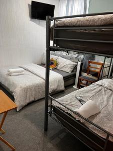 a bedroom with two bunk beds and a table at BLACKPOOL MERCY Inn HOTEL in Blackpool