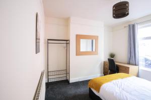 a bedroom with a bed and a desk and a mirror at RUTLAND HOUSE 10 mins from Manchester City Ctr 4-Bedroom House in Manchester
