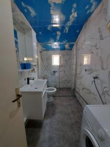 y baño con aseo, lavabo y techos azules. en Apartment Center 23, en Podgorica