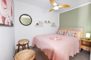 a bedroom with a pink bed and a ceiling fan at Book Jet - Casa Adam in Morro del Jable