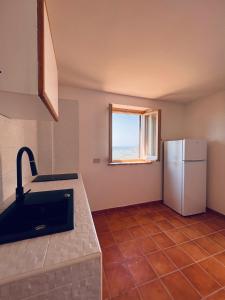 Il comprend une cuisine équipée d'un réfrigérateur et d'une fenêtre. dans l'établissement La bella vista, à Monte San Biagio