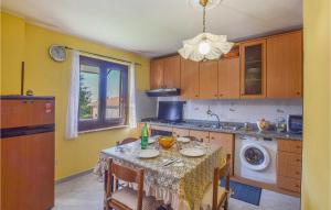 a kitchen with a table with chairs and a sink at Amazing Apartment In Ricadi With House Sea View in Ricadi