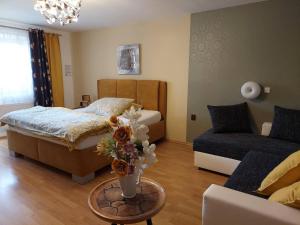 een slaapkamer met een bed en een tafel met een vaas met bloemen bij Hotel Olga in Slavkov u Brna