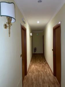 um corredor vazio com um candeeiro e pisos em madeira em Hotel Fenicia em Roma