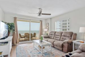 a living room with a couch and a table at Sea Winds 501 - Corner Breeze in Ormond Beach