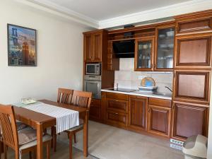 a kitchen with wooden cabinets and a table with chairs at Boruzs Apartman in Hajdúszoboszló