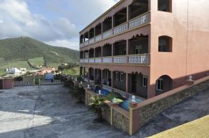 a large building with people sitting on the balcony at Coopérative Village Jbel Moussa du Tourisme in Rcham