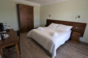 a bedroom with a white bed with two towels on it at Casale Sienti'n Può in Norcia