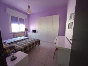 a bedroom with purple walls and a bed and a window at Affittacamere Appartamento colorato in Ferrara
