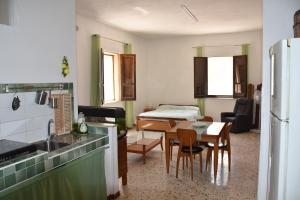 cocina y sala de estar con mesa y nevera en Casa Vacanze Adele, en Sciacca