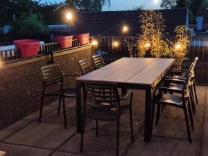 een houten tafel en stoelen op een patio in de nacht bij Gasthuis Puytvoet in Sint-Niklaas