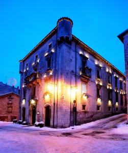 un grande edificio con luci sul lato di Hotel Le Torri a Pescocostanzo