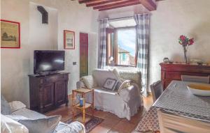 een woonkamer met een tv en een stoel en een tafel bij Pet Friendly Apartment In Suvereto With Wifi in Suvereto
