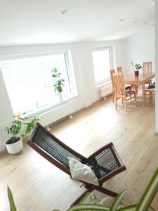 Una sala de estar con una silla y una mesa. en Bungalow in Messenähe, en Hannover